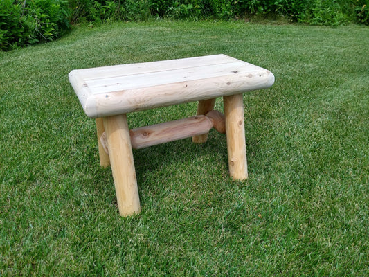 Rustic wood bench outdoor with a sturdy log frame, perfect for garden or patio seating.