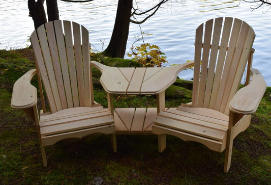  Cedar wood Adirondack chairs with a built-in table, placed near a scenic lake for outdoor relaxation.