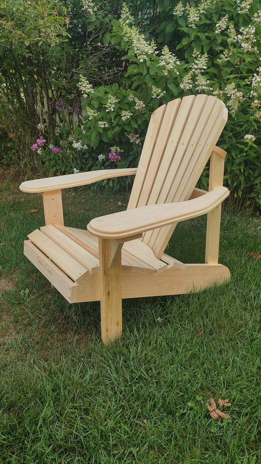 Natural wood adirondack patio chair set on a green lawn, showcasing a curved back and wide armrests.